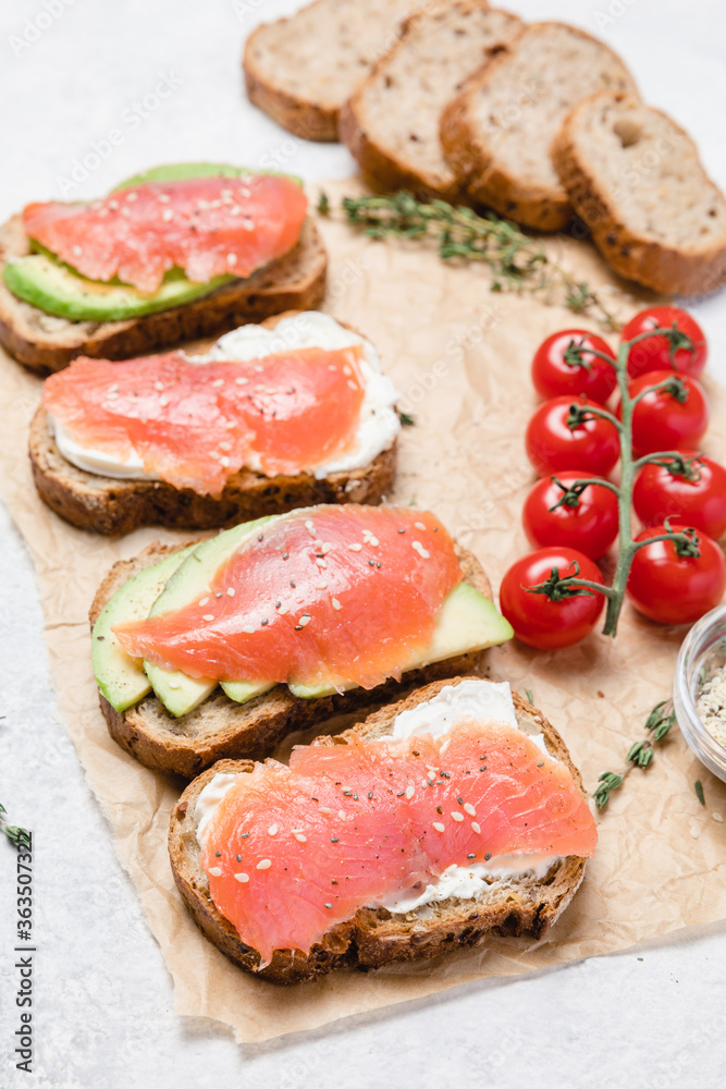 Rye bread toasts with avocado, smoked salmon and cream cheese.