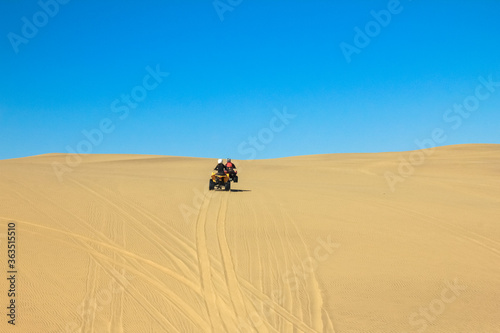 Quad driving people - two happy bikers in sand desert dunes, Africa, Namibia, Namib, Walvis Bay, Swakopmund. © Drepicter