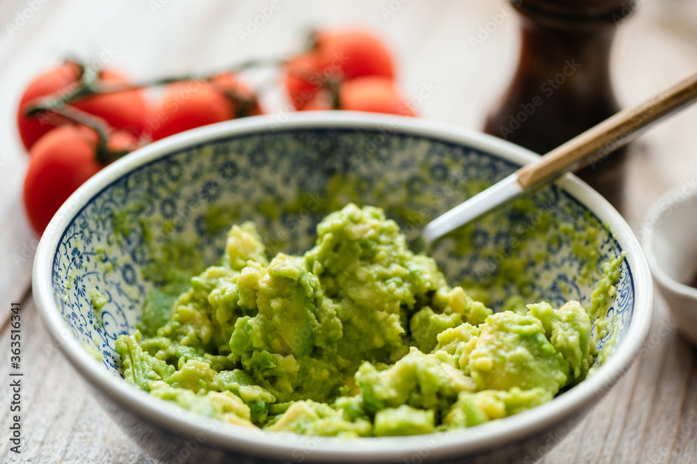 Mashed avocado in a bowl. Guacamole sauce, avocado mash. Closeup view, selective focus Mashed avocado in a bowl. Guacamole sauce, avocado mash. Closeup view, selective focus