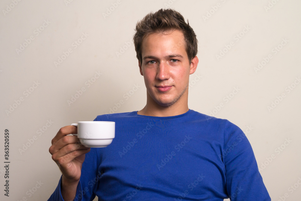 Portrait of young handsome man holding coffee cup Portrait of young handsome man holding coffee cup