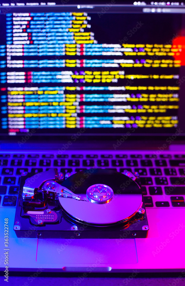 Hard drive on a laptop keyboard. Reflection of program code from the ...
