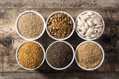 Assortment of different seeds in bowl on wooden table. Pumpkin, linen, chia, sunflower and sesame seeds. 