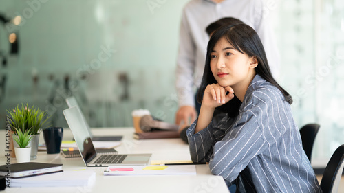 Portrait of young business woman working and thinking in the office..