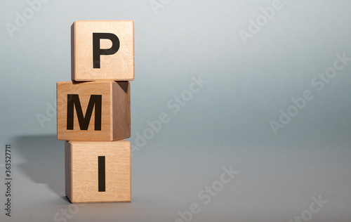 PMI acronym word from wooden blocks with letters, abbreviation PMI Private Mortgage Insurance, Purchasing Managers Index concept with copy space photo