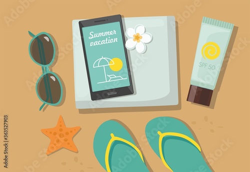 Composition with beach accessories. Sunglasses, towel, sun block, flip-flops and phone on sandy beach