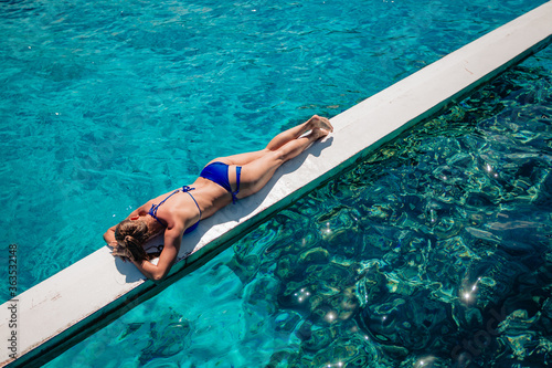 young woman in bikini posing upon water