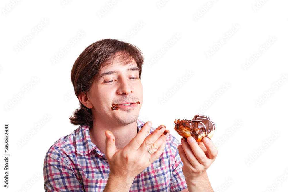 A man eats a doughnut and licks, a very funny photo on a white background. Empty space for text. A man loves sweets chocolate. World Chocolate Day stock images
