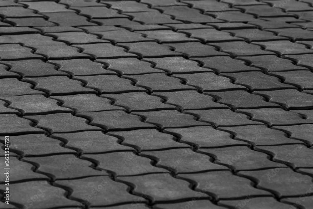 Abstract background of grey concrete paving stones. Shaped paving stones in perspective. Tiles on the pavement. Paved road in the Park. Street textures. Stone mosaic.