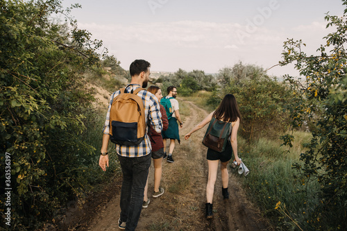 Group of tourists hiking in mountains  walking on a dirt path.