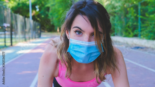 A girl prepared to run on a running track with the mask to avoid the Covid virus 19