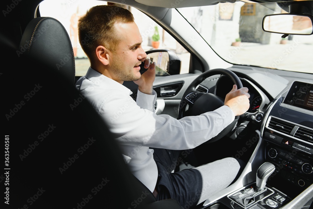 young businessman in his car at the wheel talking on a mobile phone young businessman in his car at the wheel talking on a mobile phone