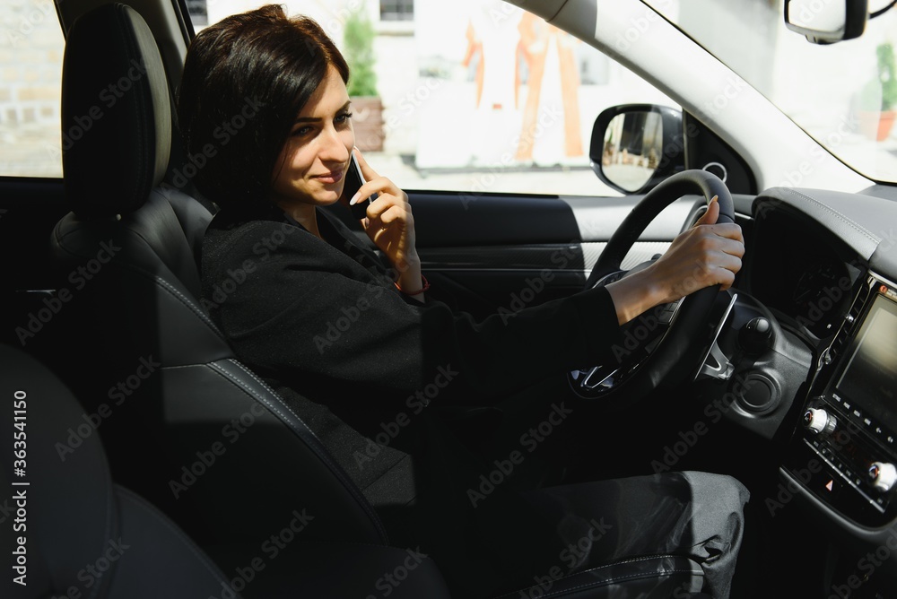 Businesswoman sitting in drivers seat in her car Businesswoman sitting in drivers seat in her car