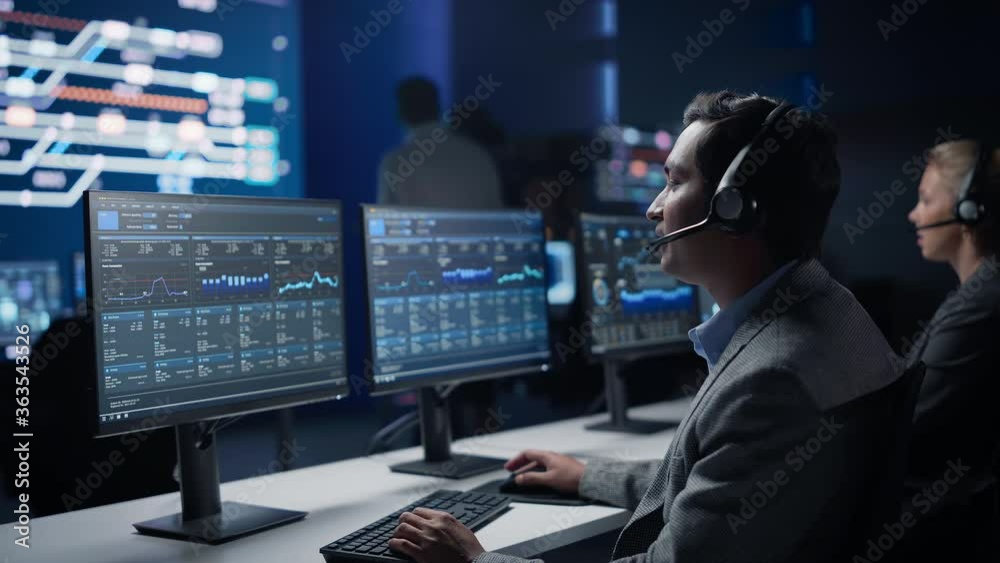 Team of Professional Traders Talking into Headsets Work on Computers with Screen Showing Finance Statistics, Charts Strategy, Stock, Telemarketing. Stock Firm Monitoring Room Stock Market Specialists Team of Professional Traders Talking into Headsets Work on Computers with Screen Showing Finance Statistics, Charts Strategy, Stock, Telemarketing. Stock Firm Monitoring Room Stock Market Specialists