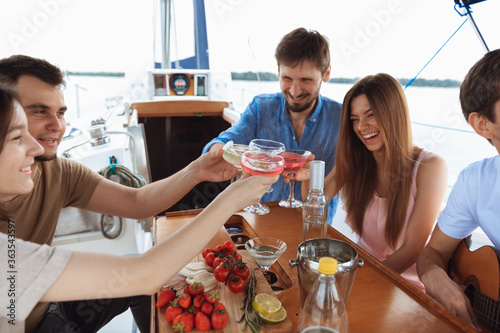 Photography Group of happy friends drinking vodka cocktails at boat party outdoor, cheerful and happy