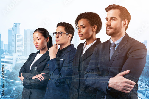 Photography Four successful business consultants standing in a row in suits and ready to tackle with customer problem