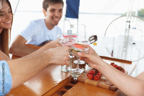Wall Mural Group of happy friends drinking vodka cocktails at boat party outdoor, cheerful and happy
