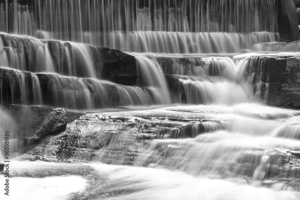 Fototapeta premium Buttermilk Falls and Mill in Forest Mills Ontario with long exposure waterfalls and original Mill in the forest.