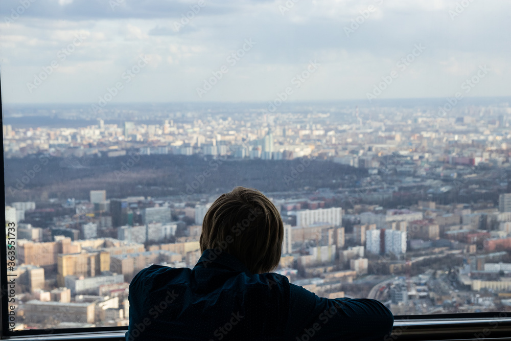 Russia, Moscow, 2019: Ostankino TV tower, a man looks at the panorama of a huge city