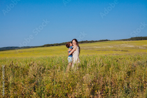 Portrait of a beautiful mom and son on a walk on nature field road