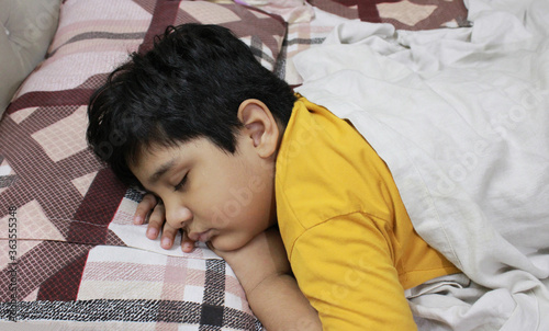 Young boy sleeping on bed