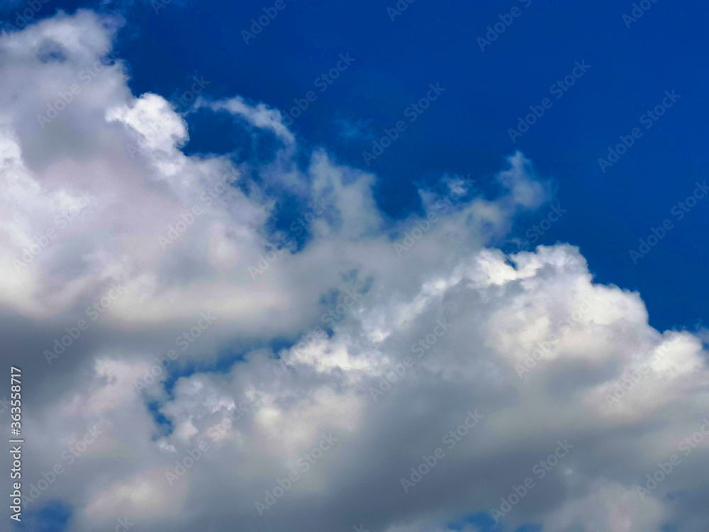 Large white clouds in the blue sky on a clear day