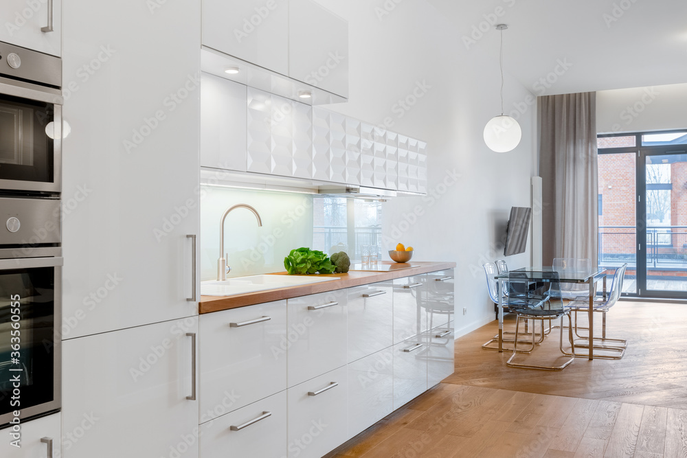 Fototapeta premium Biała kuchnia otwarta na jadalnię