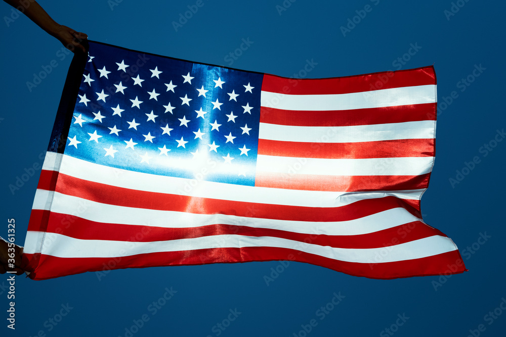 Fototapeta premium man waving an American flag on the wind