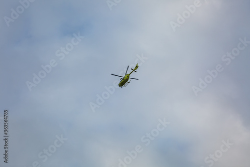 Helicopter flying in cloudy blue sky