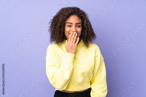 Young African American woman isolated on background happy and smiling covering mouth with hand © luismolinero