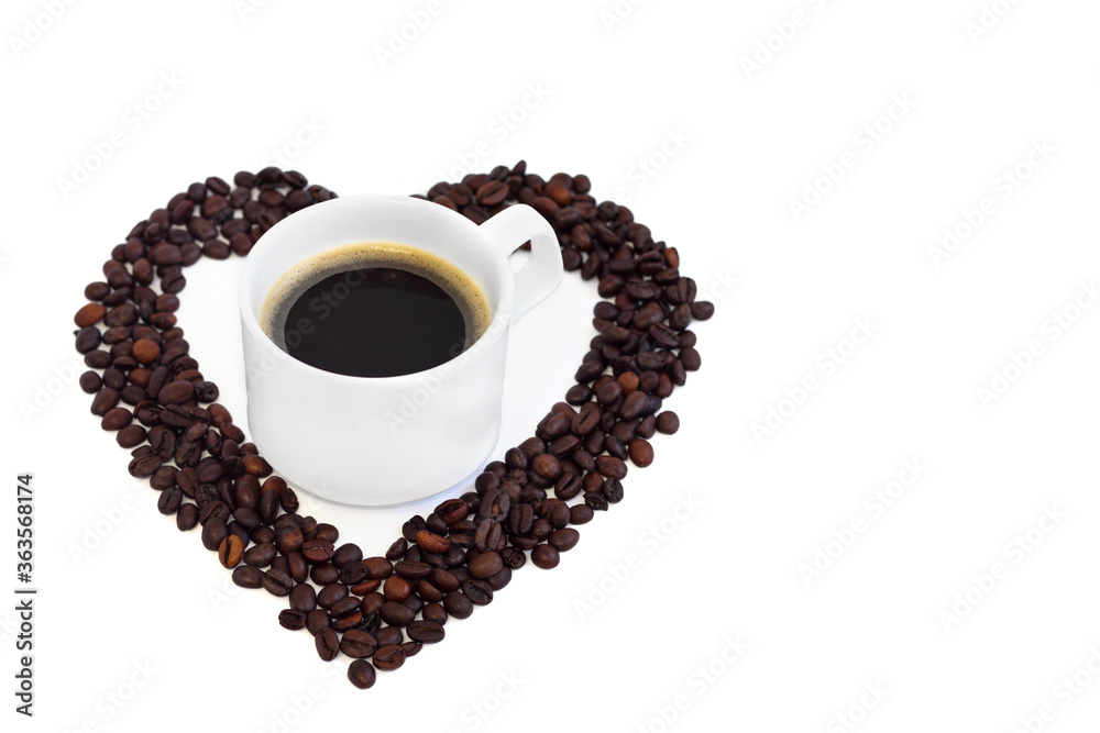A heart made of coffee beans, a cup of coffee stands in the middle. Cup of coffee isolated on a white background.