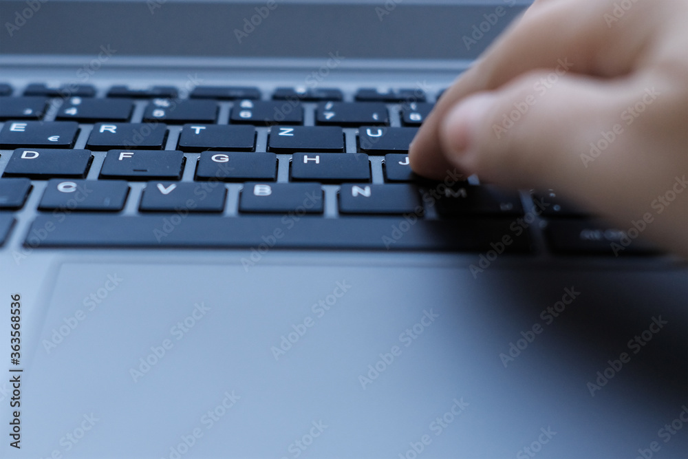 woman is typing on laptop keyboard, selective focus, working in evening at laptop of his house, hands closeup, concept of remote work, quarantine, downshifting