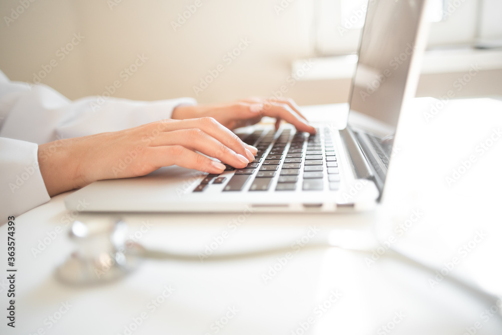 doctor is typing on a laptop keyboard. online doctor consultation. High quality photo doctor is typing on a laptop keyboard. online doctor consultation. High quality photo