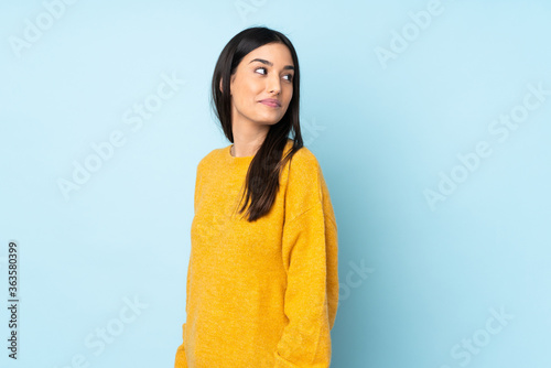 Young caucasian woman isolated on blue background . Portrait