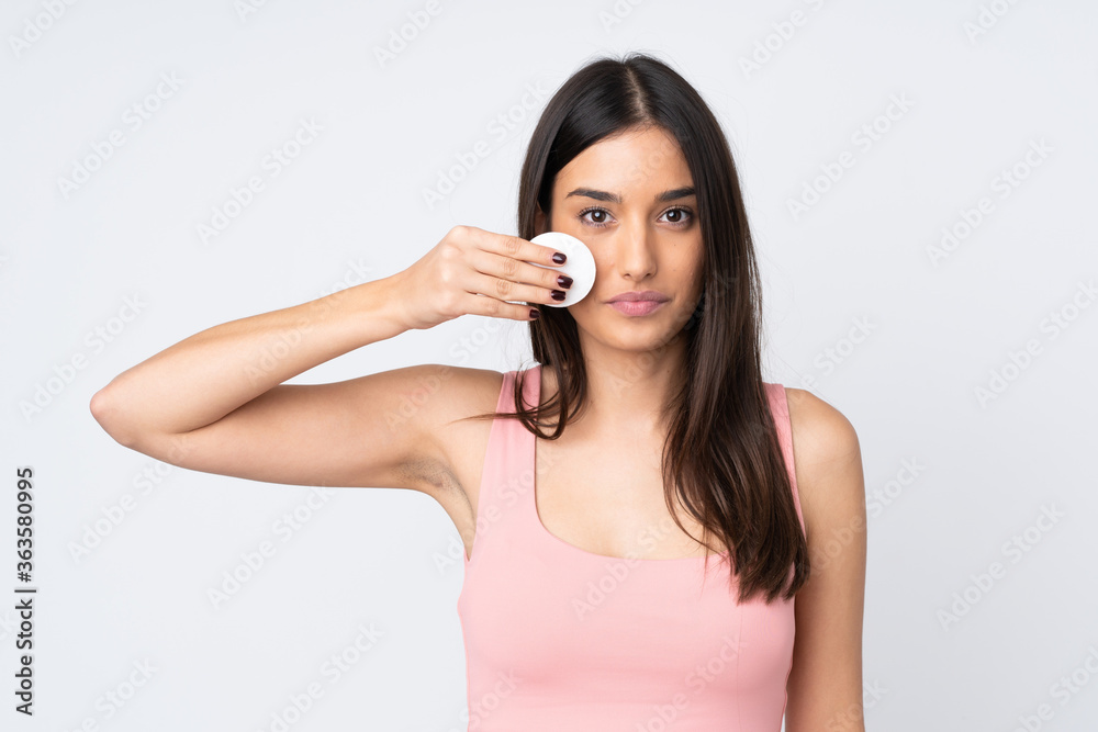 Young caucasian woman isolated on white background with cotton pad for removing makeup from her face Young caucasian woman isolated on white background with cotton pad for removing makeup from her face