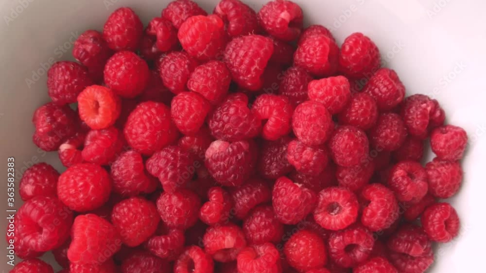 Juicy fresh raspberries with water drops in motion. beautiful bokeh