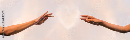 Banner. Two thin graceful female hands reach out to the heart from the clouds between them.