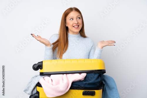 Traveler woman with a suitcase full of clothes with surprise facial expression