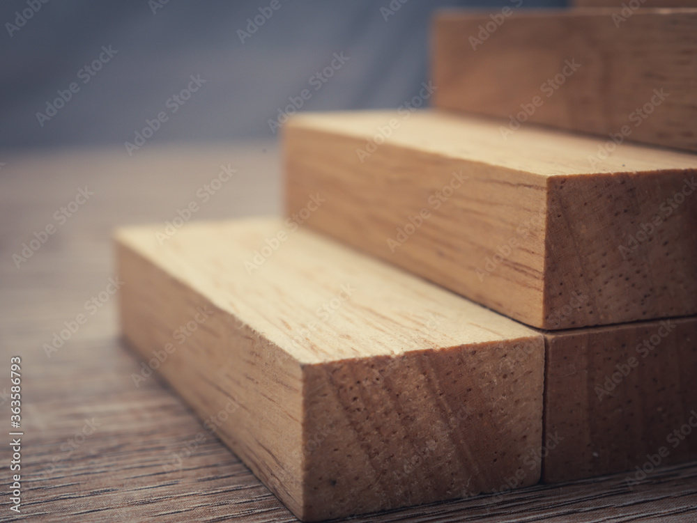 Arranging wood cube block stacking for top staircase shape on wooden table,Business concept and growth success process