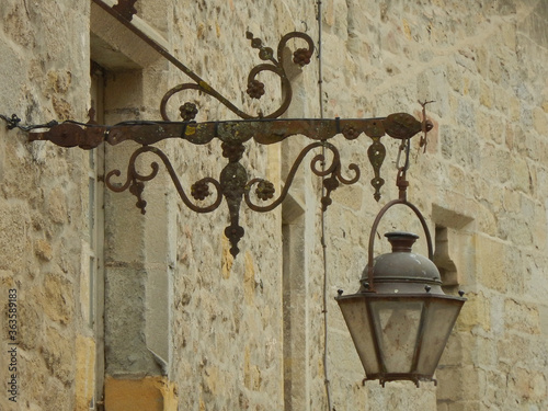 Antique hand-wrought iron bracket with hanging lantern