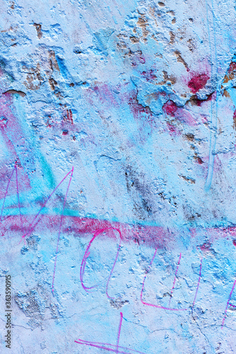 Hooligan smeared paint the walls of the old building. Landscape style. Grungy concrete surface with cracks, scratches and streaks of paint. Great background or texture.