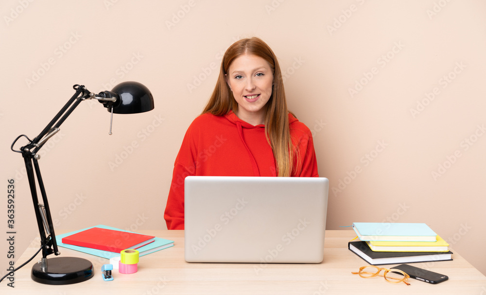 Young student woman in a workplace with a laptop laughing Young student woman in a workplace with a laptop laughing