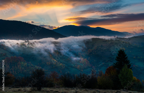 Bright colorful sunrise in mountains with smoke and dramatic bright sky