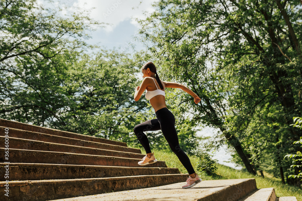 Healthy lifestyle, sport. Woman running up on stone stairs. Sportswoman running up the steps as a part of workout routine. The sport girl climbs the stairs. Healthy lifestyle, sport. Woman running up on stone stairs. Sportswoman running up the steps as a part of workout routine. The sport girl climbs the stairs.
