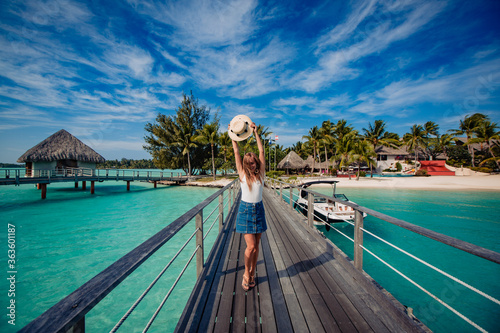 beautiful blonde girl  posing on dock, tropical resort in background photo