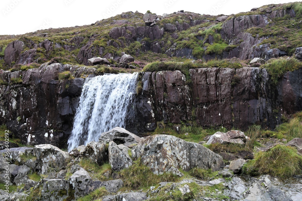 A waterfall on the way up Conor Pass which is a high narrow road over the mountains in the centre of the Dingle Peninsula, in County Kerry, Ireland.