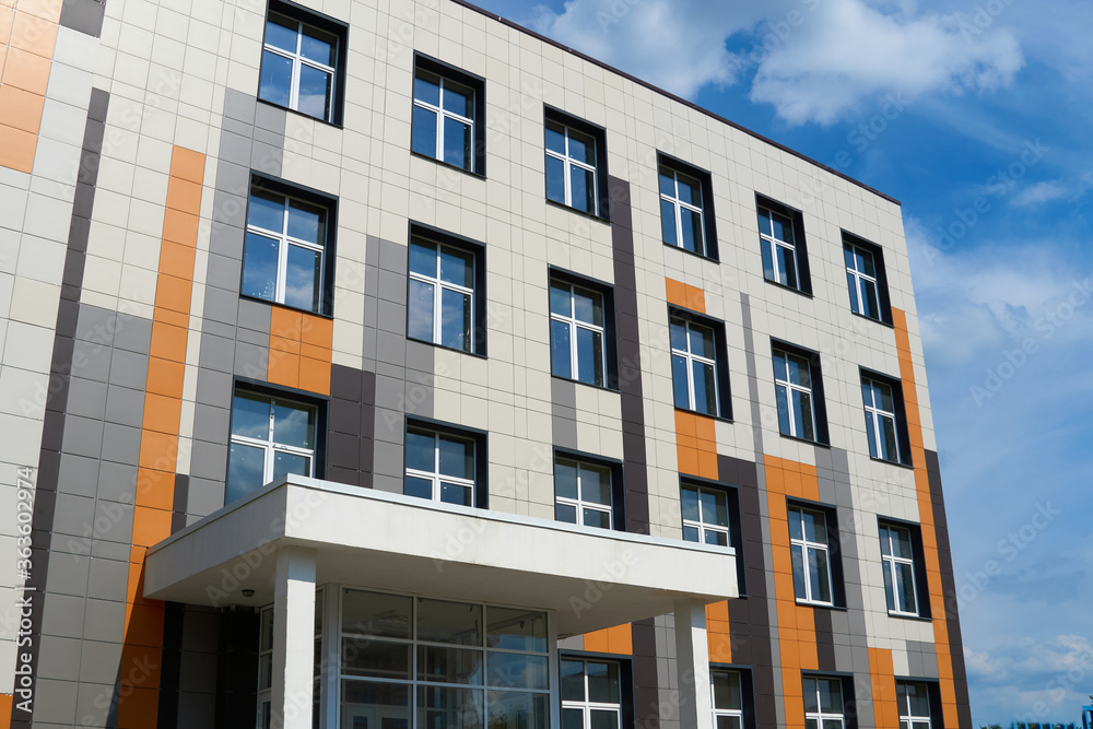 facade of a modern building on a bright Sunny day, siding and Windows, beautiful exterior of the new building