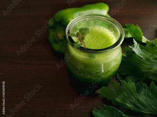 green detox juice on wooden table and captured with selective focus photo