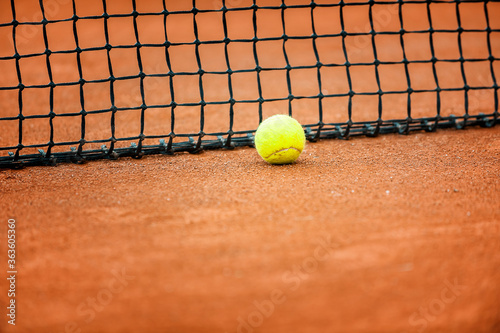 Close up of a tennis court net with tennis ball..
