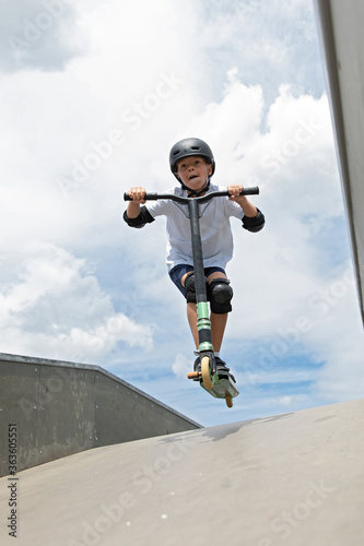 Obraz na płótnie The boy jumps on a scooter. w salonie