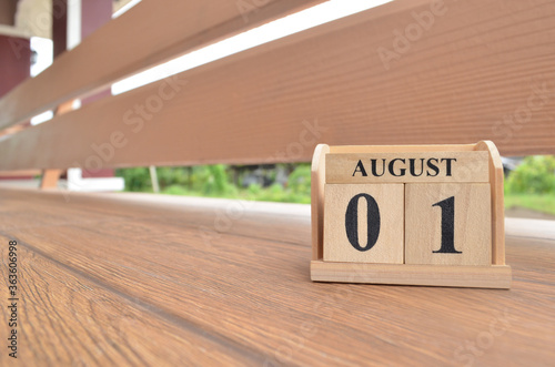 August 1, Number cube with wooden balcony background.